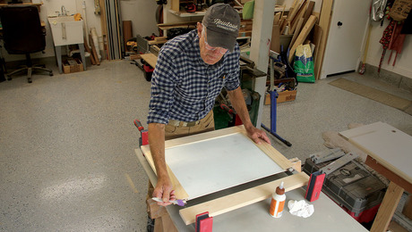 Photo of the author, Tim, glueing together pieces of a wooden cabinet.