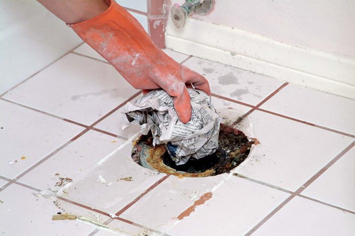 Plug the sewer line with a wad of newspaper to prevent the escape of gases.