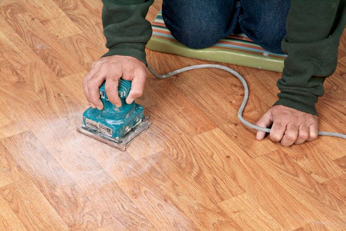 Sanding a vinyl floor with 60-grit sandpaper will give it the “tooth” it needs for adhering backerboard to it with thinset.