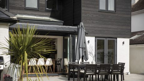 Two-story home with dark cladding that looks wood-like