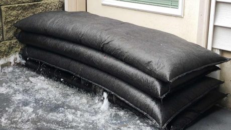 Quick Dam flood bags stopping the flow of water in front of a door