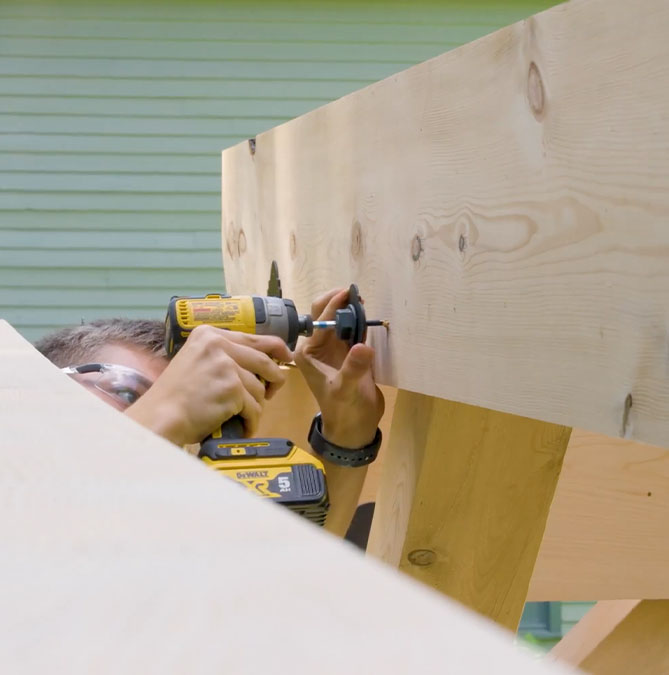 Photo of Jeremy Kassel installing angle bracing and securing it with decorative washers.