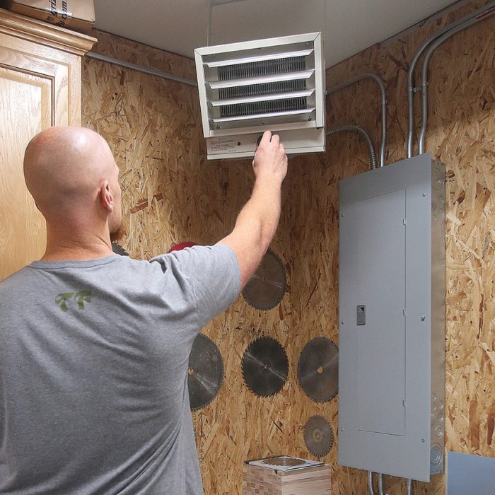 Photo of Casey Knips installing a small shop heater.