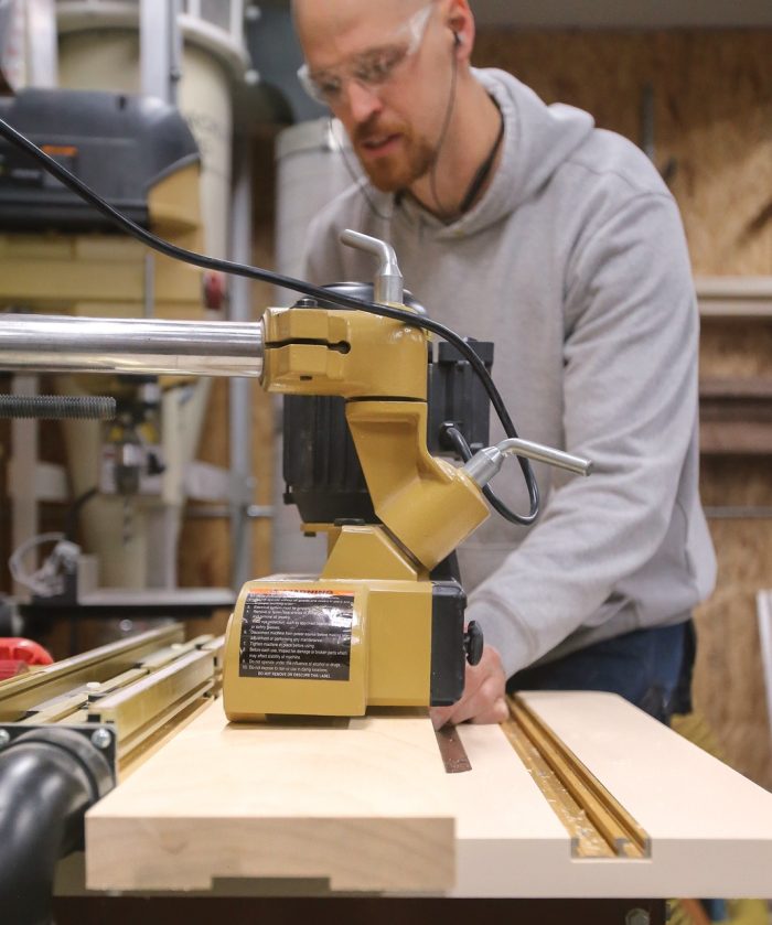 Photo of Casey Knips using a router on his custom router table.