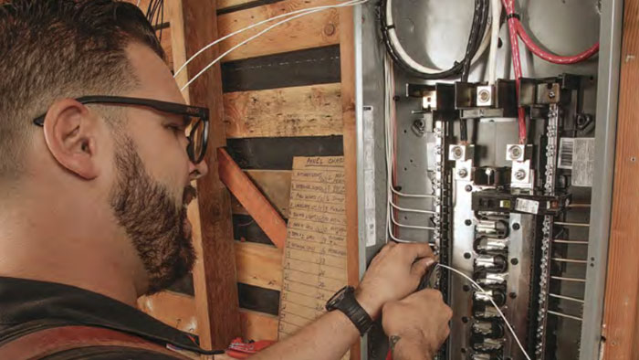 electrician wiring a circuit panel